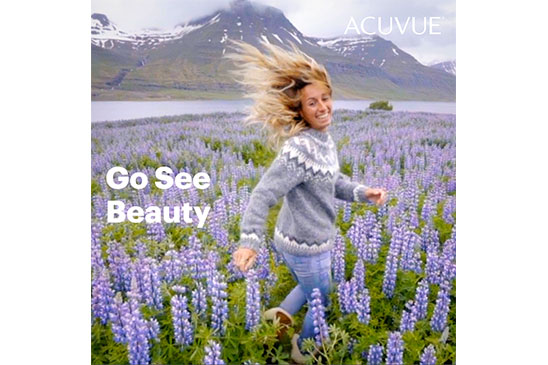 Woman walking through flowers, go have an adventure with ACUVUE contact lenses.